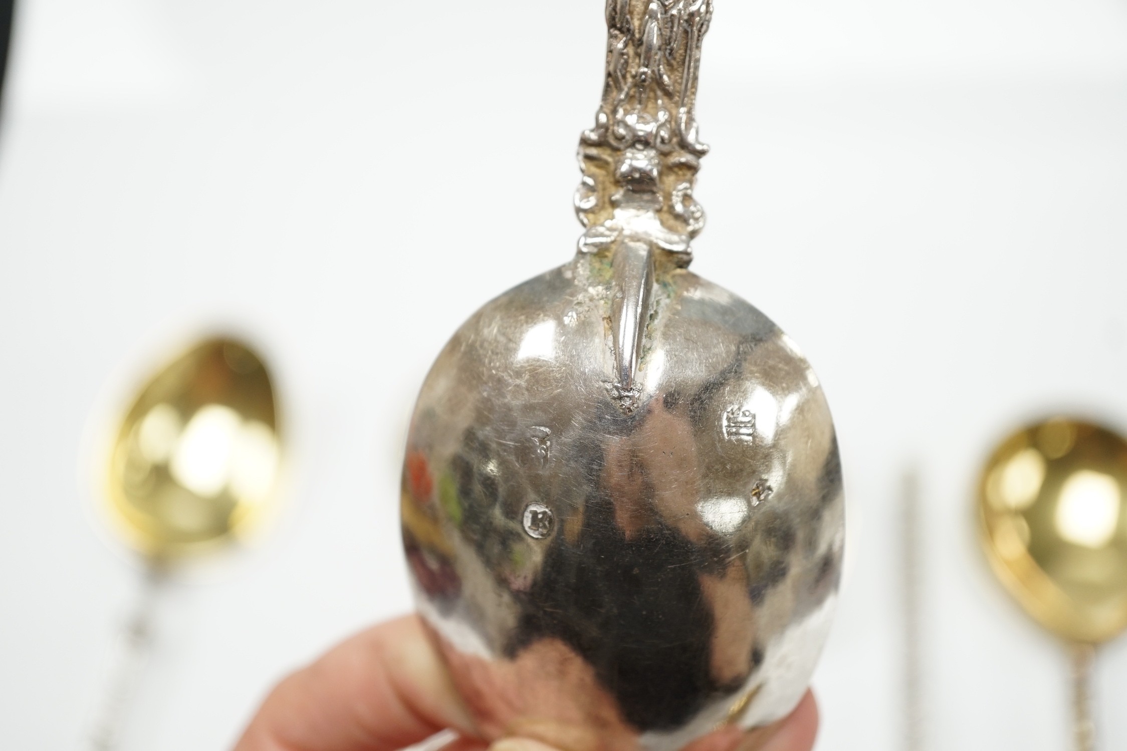 Twelve assorted 19th century and later Scandinavian or Dutch? gilt or parcel gilt white metal spoons, with differing stems including apostle, largest 18.8cm, 19.3oz.
